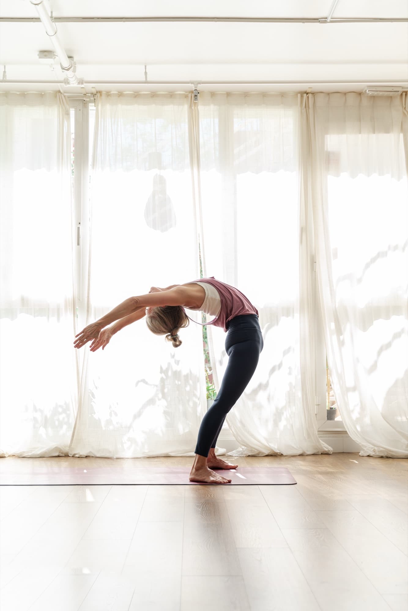 Lotta in a standing backbend by the studio windows